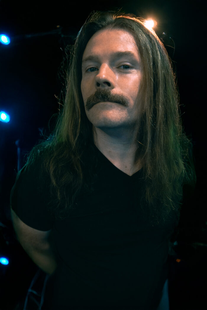 Sean Bolton Photographer on a stage with and AI background