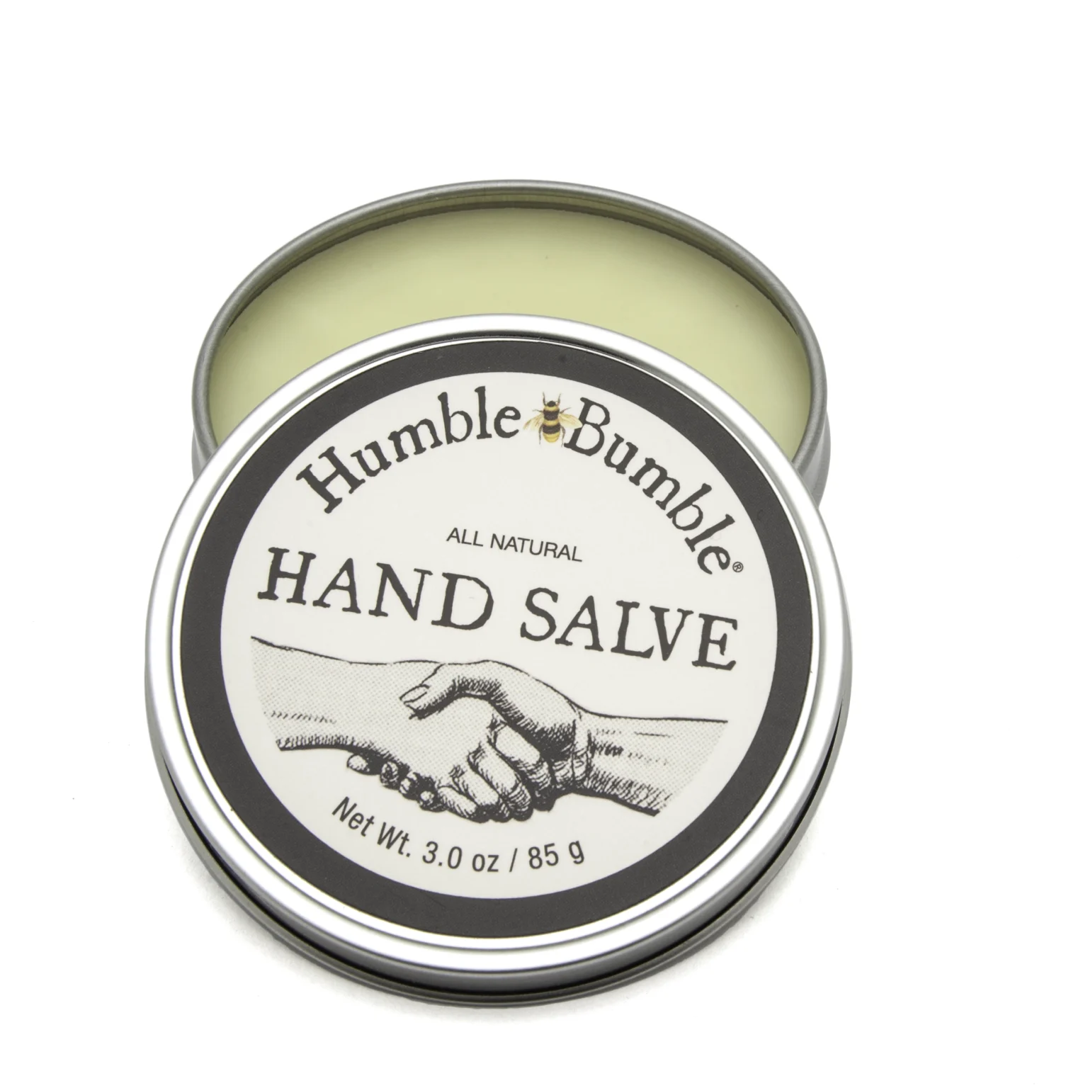 Open tin of Humble Bumble all-natural hand salve with classic handshake illustration on white background